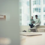 Business people with digital tablet sitting on win 2026 01 05 00 58 45 utc - Hva gjør et digitalt byrå? Tjenester, priser og hvordan du velg...