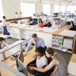 Colleagues working at a woman s workstation in a b 2026 01 05 06 29 08 utc - Hva er B2B‑samarbeid mellom bedrifter?