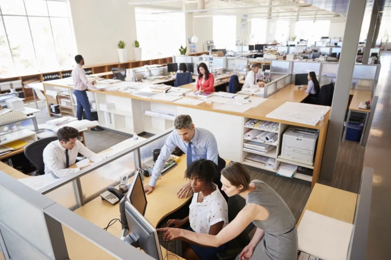 Colleagues working at a woman s workstation in a b 2026 01 05 06 29 08 utc - Hva er B2B‑samarbeid mellom bedrifter?