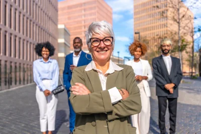 Mature smiling businesswoman standing proud next t 2026 03 16 02 08 09 utc - Kommunikasjon i arbeidslivet