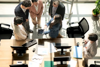 Multicultural business team standing around a desk 2026 03 05 11 48 53 utc - Outsourcing vs in-house: Økonomisk sammenligning for møtebookin...