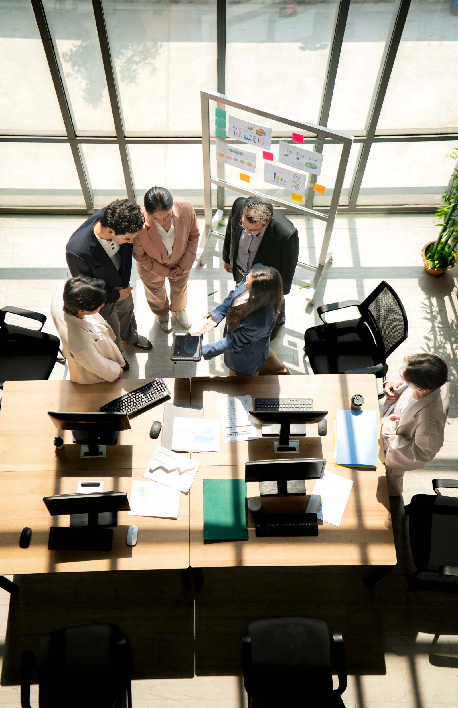 Multicultural business team standing around a desk 2026 03 05 11 48 53 utc - Outsourcing vs in-house: Økonomisk sammenligning for møtebookin...
