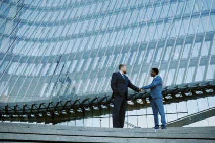 Shaking hands in corporate glass building 2026 01 08 00 31 14 utc - Teknologivalg for tverrbedrifts-samarbeid: skybasert ERP og integrasjons...