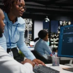 Two black workers interacting with a virtual assis 2026 01 11 10 55 41 utc - Slik skriver du en vinnende søknad til Innovasjon Norge (steg f...